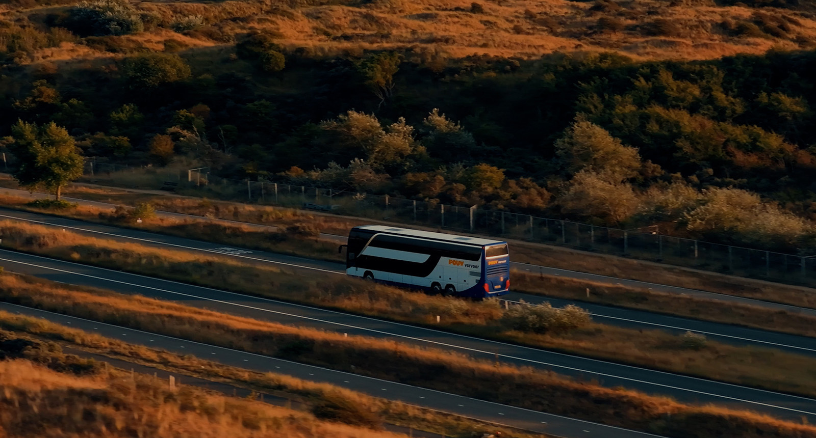 Touringcar van Pouw Vervoer geparkeerd op de Mont Ventoux in Frankrijk, met het herkenbare witte weerstation op de top van de berg op de achtergrond. De bus vervoerde studenten en begeleiders van ROC Midden Nederland voor deelname aan de Tour du ALS.